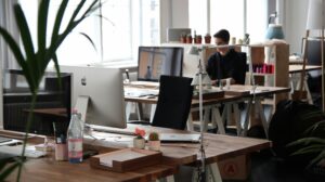 Remote creative team using Figma and Miro on laptops, collaborating on design files in real-time in a modern workspace, 2025.